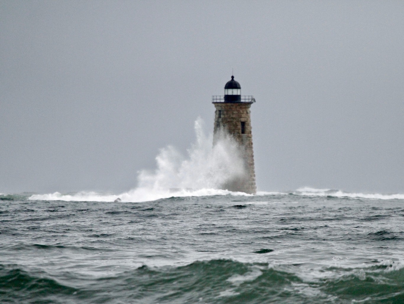 a wave breaks on the edge of a lighthouse