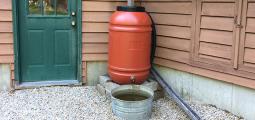  a rain barrel is situated next to a house