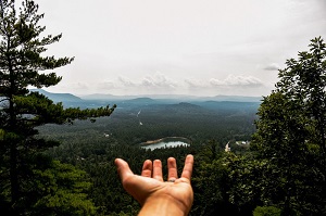 a hand stretches out before a landscape view