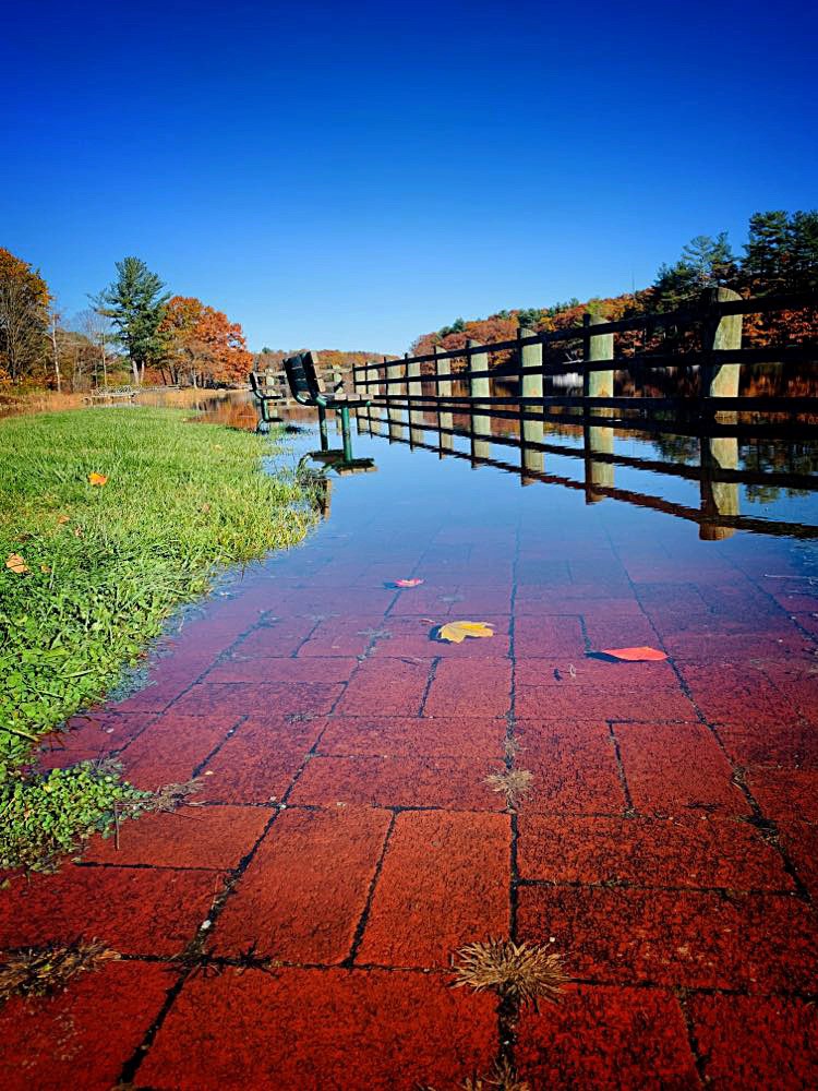 a red brick sidewalk is covered in rising waters