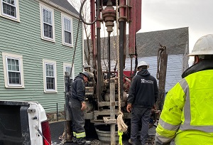 People working to Install a well for groundwater test borings at the Black Heritage Trail of New Hampshire building.
