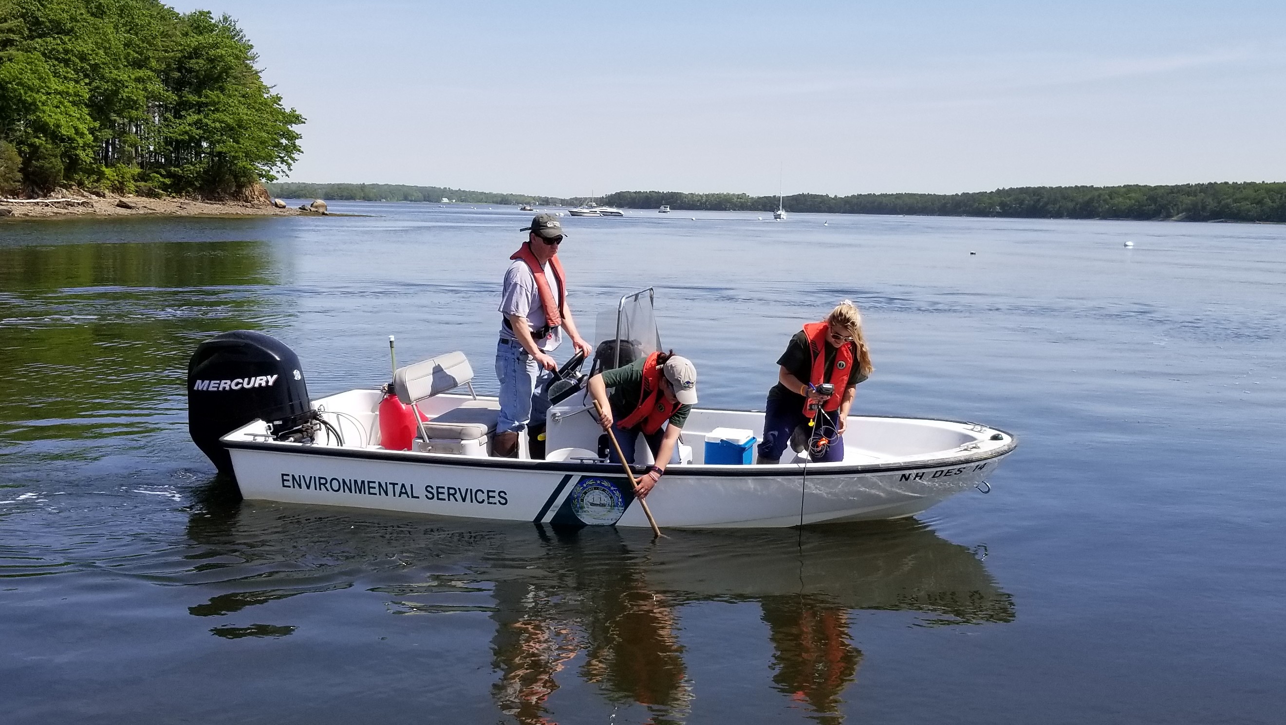 photo of team in a boat collecting water quality samples in shellfish harvest area 