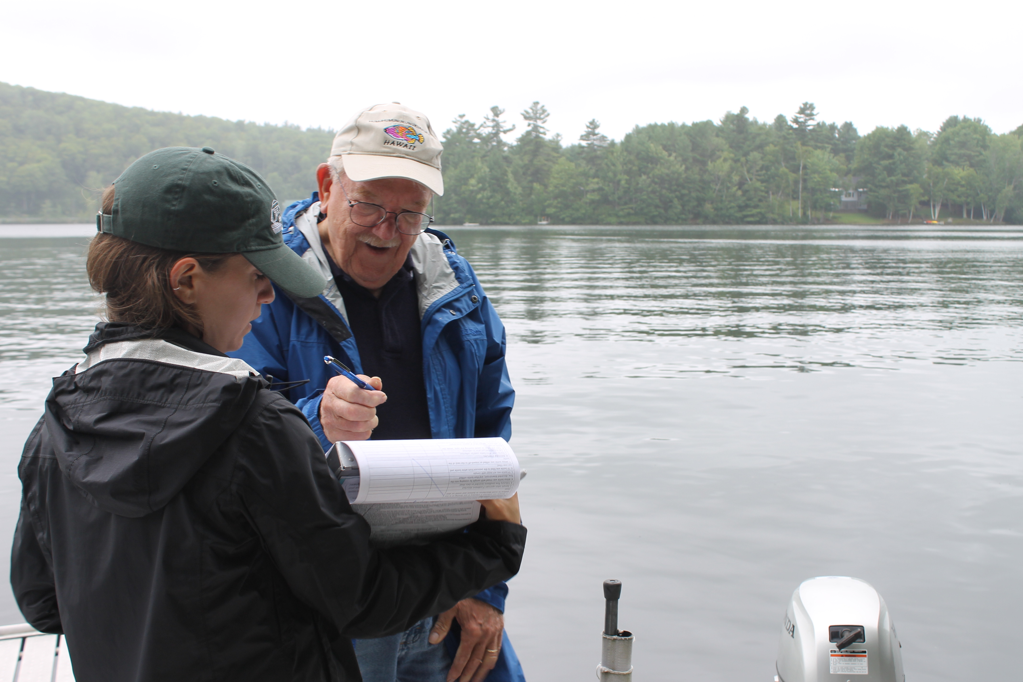 An NHDES intern works with a VLAP volunteer on a dock.