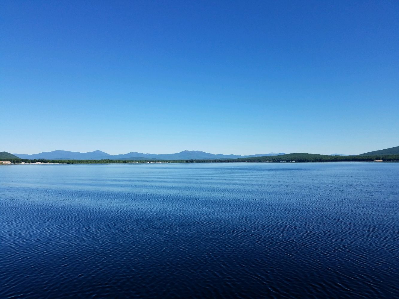 A flat blue lake and blue sky.