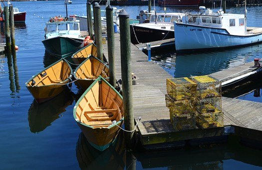 lobster boats and lobster traps at a dock.