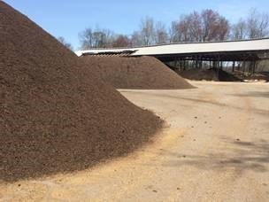 stockpiles of materials on asphalt with a covered area in the background at the Merrimack facility 