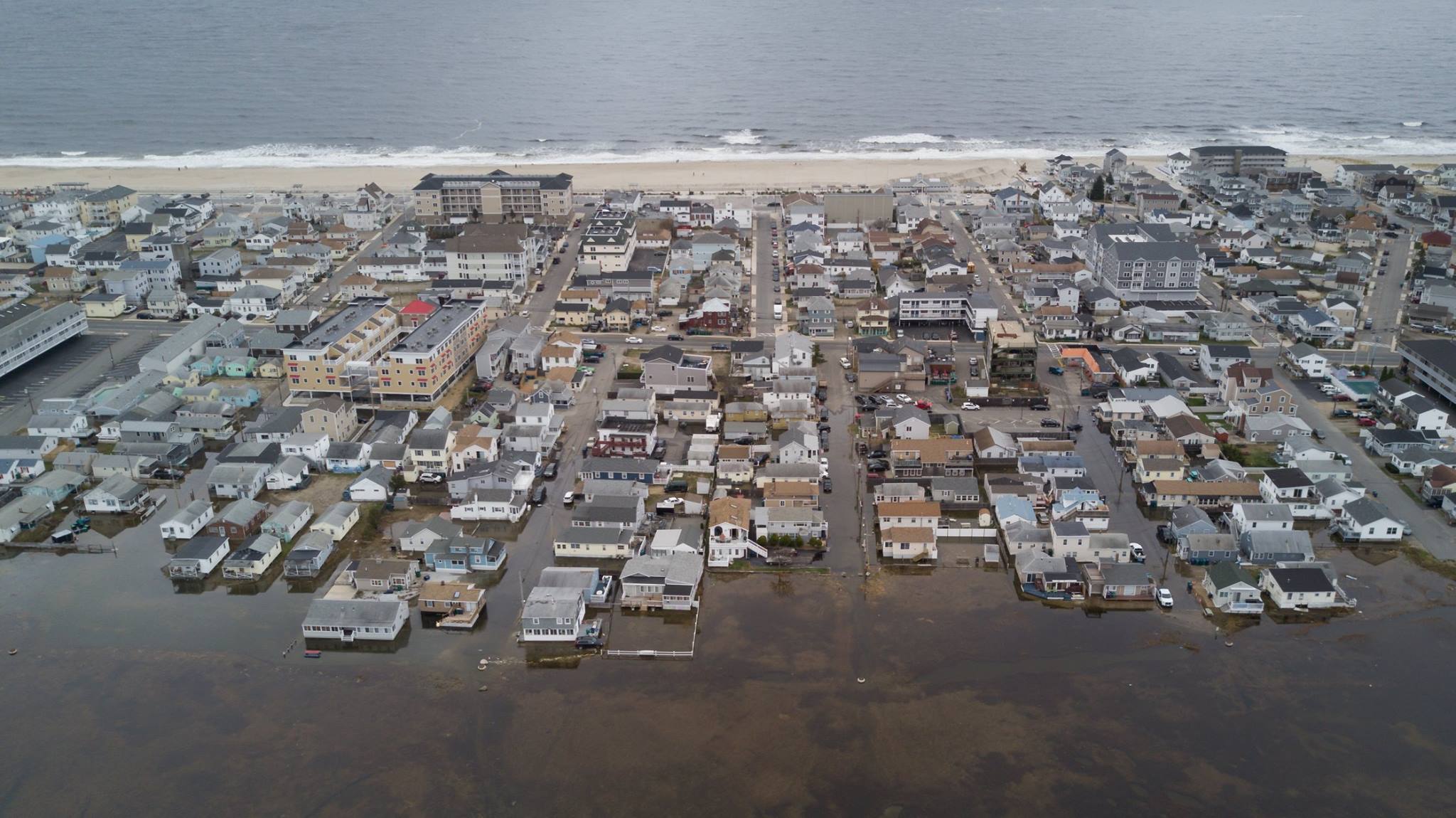 drone aerial image of Hampton neighborhood flooded during King Tide in foreground and beach in background. 