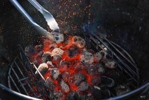 cooking grill filled with black charcoal and red embers