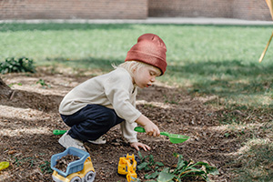 An Image of a young child digging in the dirt
