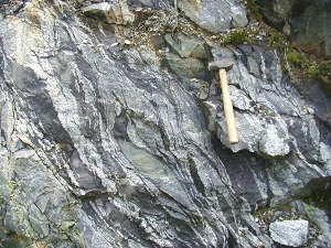 a hammer rests on exposed bedrock