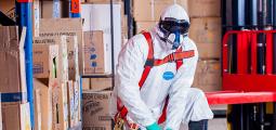 a person in a hazmat suite surrounded by chemicals
