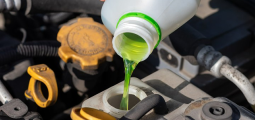 green antifreeze being poured into an open car hood