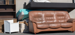 a pile of large furniture with a couch, bookshelf, box spring and mattresses