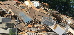 pile of used materials including wood paneling, pallets and window screens
