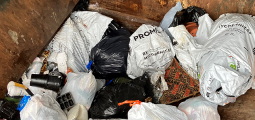 garbage bags piled in a trash compactor