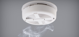white smoke alarm mounted on a ceiling